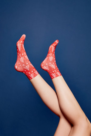 Woman leg in red grey christmas socks.