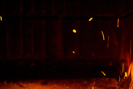 Fire sparks in the air near the fireplace on black