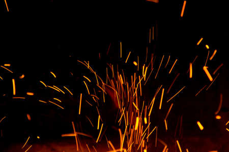 Fire sparks in the air near the fireplace on blackの写真素材
