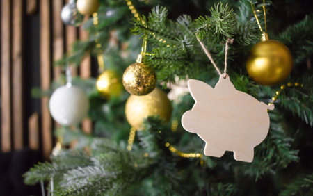 Pig toy the Christmas tree. Golden balls, beads, other decorations. New Year symbol concept.