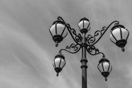 Decorative retro street lamp or lamppost on sky background with black and whiteの写真素材