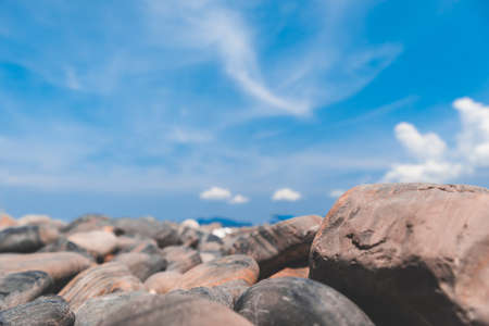 Pebble stone beach on blue sky background with shallow depth of fieldの写真素材
