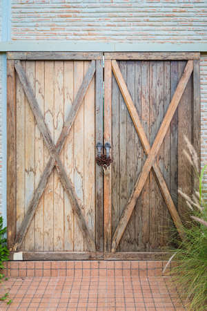 Old wooden double door was locked with rusty chain and padlock.の写真素材