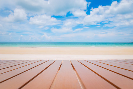 Selective focus of wooden table on tropical beach with 
turquoise sea and blue sky.の写真素材