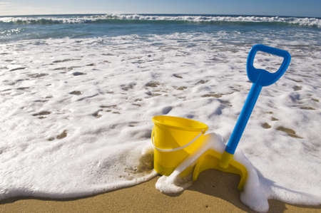 Beach scene, Spade and bucket at the waters edge.の写真素材