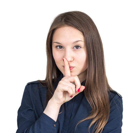 Brown-haired girl in a shirt presses a finger to her lips
