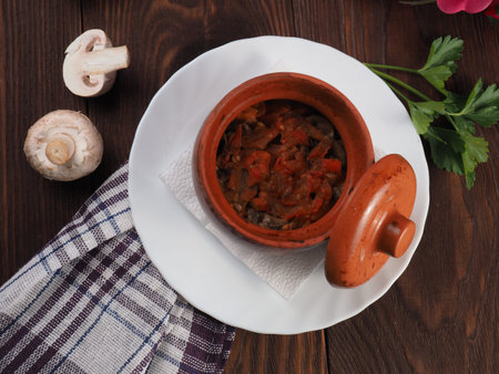 Mushroom stew with potted vegetables and raw mushrooms on a rustic table