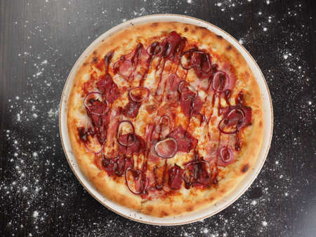 Pizza in a plate with ingredients on a dark backgroundの写真素材