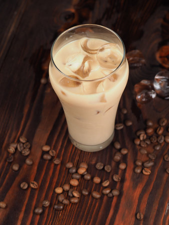 Milk shake with coffee and ice on a wooden table