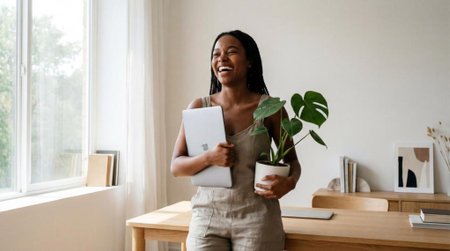 happy businesswoman holding digital tablet and plant in officeの素材