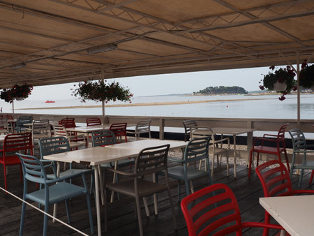 Restaurant on the beach with tables, chairs and umbrellasの写真素材