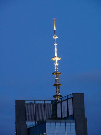 Modern Skyscraper with Unique Antenna Structure Against Deep Blue Evening Sky