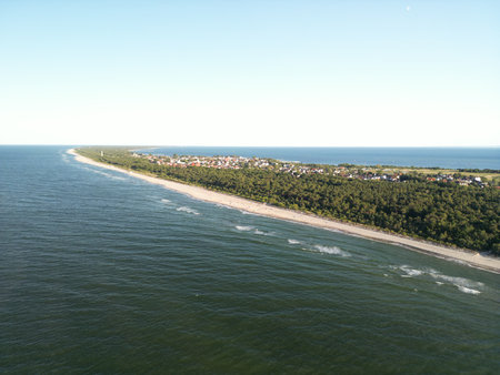 Dramatic aerial perspective of Baltic Sea waves crashing against verdant coastal forestの写真素材