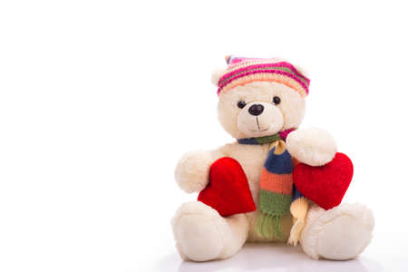 Teddy bear sitting with two valentine hearts isolated on whiteの写真素材