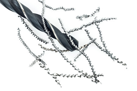 Drill and metal shavings on white の写真素材