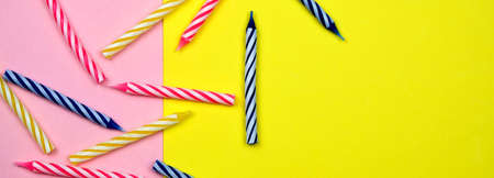 Colorful Candles For Birthday Party On The Pastel Yellow And Pink Background Minimal Style Flat Lay Concept Of Celebration Long Banner With Copy Spaceの写真素材