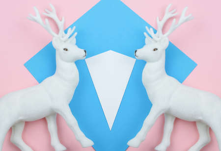 White Toy Deer On The Pastel Colors Blue And Pink Background Geometry Minimal Style Flat Lay Copy Space Creative Winter Conceptの写真素材
