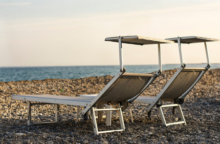 Two beach chairs on beach  coast of French Riviera Start of the season  Sunset