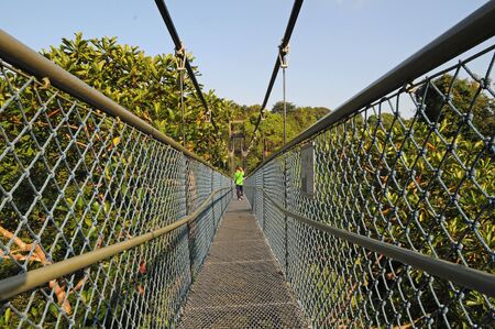 Man Crossing A Suspension Bridgeの写真素材