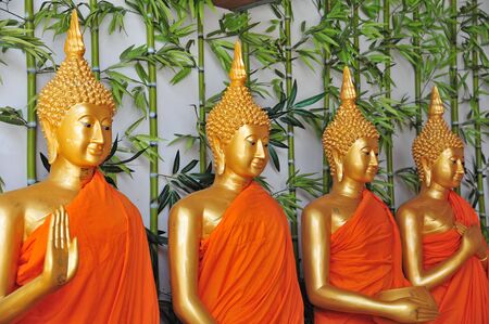Row Of Buddha Statues Dressed In Orange Robes の写真素材