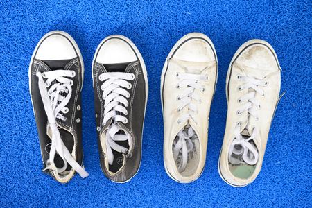 Worn Canvas Shoes On A Blue Floor Matの写真素材