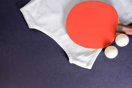 Ping pong. Table tennis rackets, balls and sports shirt on a dark background closeupの写真素材
