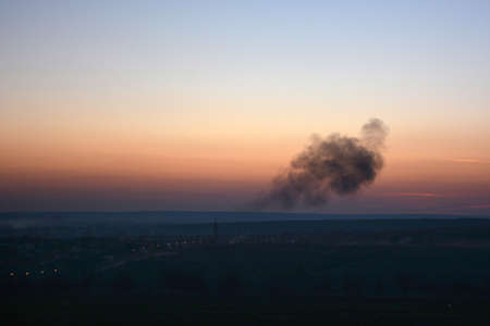 Thick tangle of smoke on the horizon at sunset in the distanceの写真素材