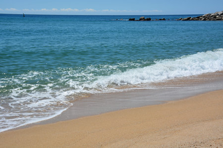 Clean beach of the Mediterranean Sea on a sunny day. Holidays in Spain
