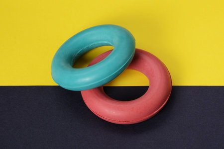 Expander rubber hand rings trainers on bright background. Gym sport equipment