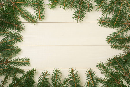 Christmas tree frame branches on wooden background with copy space. Horizontal template top view for...