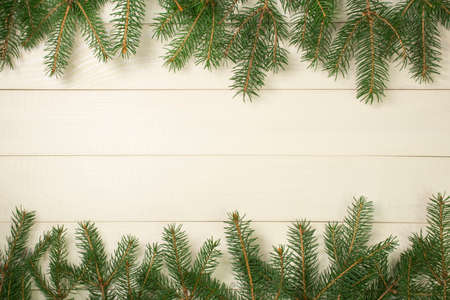 Christmas tree frame branches on wooden background with copy space. Horizontal template top view for designの写真素材