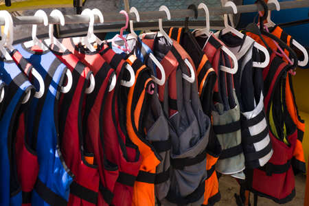 Life jackets on hanger closeup. Colorful life vestsの写真素材