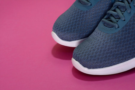 Sport sneakers on pink background with copy space for text. Sport objects background. Sports concept