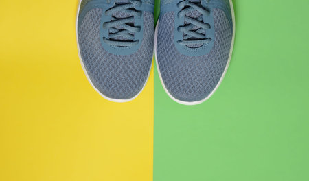Sport sneakers on yellow green background with copy space for text. Sport objects background. Sports...