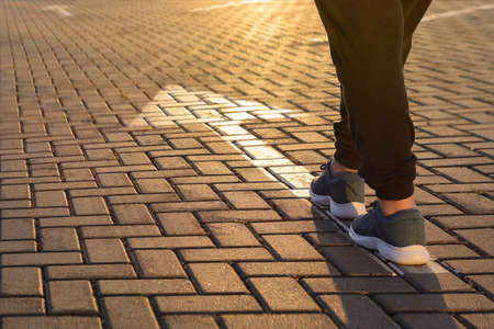 Forward moving. Feet on road arrow in the rays of setting sunの写真素材