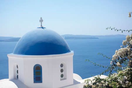 Santorini blue dome of white church in Oia with sea view and volcano, Greece landmark. island architecture.の写真素材