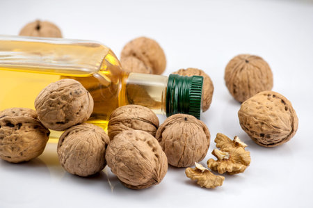 Walnutd and a bottle nut oil on the white background