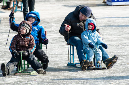 Father play sleigh with his three kids