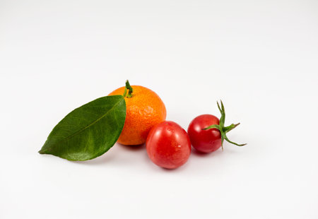 one orange and two tomatoes on the white background