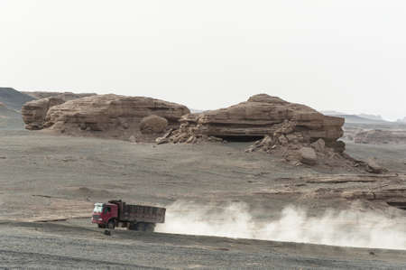 A heavy truck passing Yardang landform in Dunhuang, Gansu of Chinaの写真素材