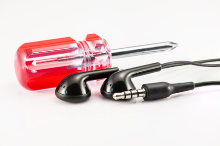 Earphone and screwdriver on the white background