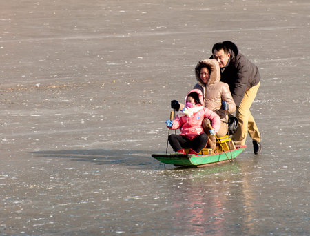 father push the sleigh faster and his wife and daughter sitted on