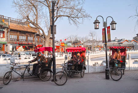 Three Chinese pedicab drivers wait for the tourist at the lakeside of ShiChaHai, Beijingのeditorial素材