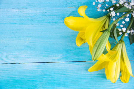 Yellow and white flowers on blue painted wooden background