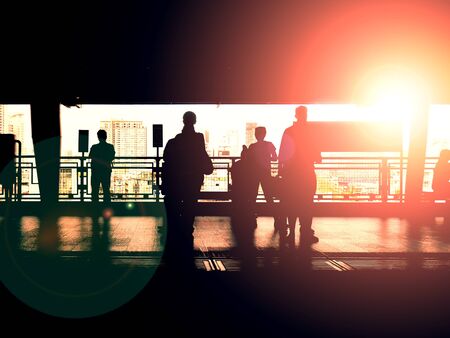 Silhouette of people waiting at train's platform with backlightの写真素材
