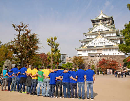 Tourists in colorful t-shirts in front of Osaka Castleのeditorial素材