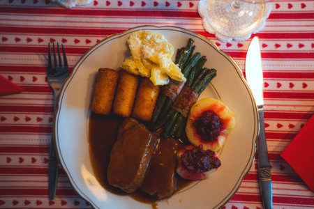 Duck breast fillet with fried potatoes, asparagus, berry sauce and scrambled eggsの写真素材