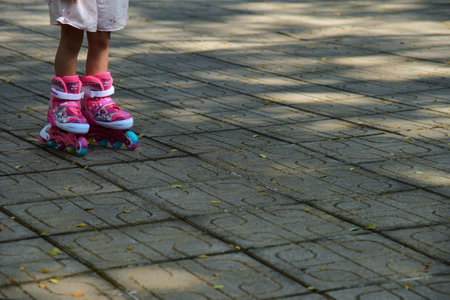 Little girl on roller skates in the park, close-up