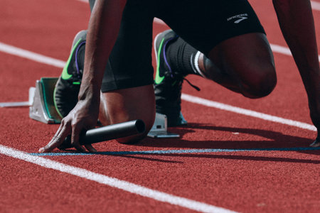athlete in start position on the running track, close-up