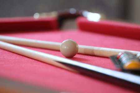 Billiard balls and cue on a red billiard table, shallow depth of field